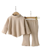 Beige ribbed sweater and pants set with shoes on a wooden floor.